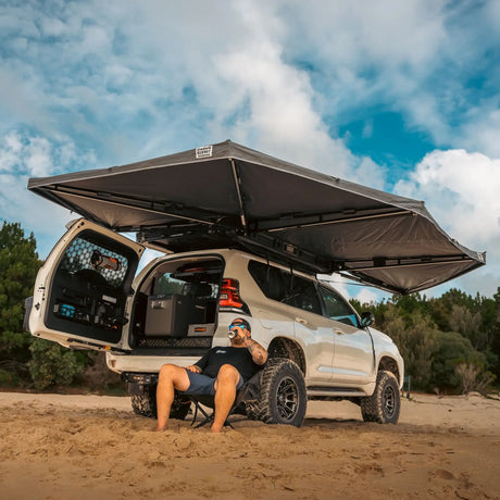 Outback Tourer Drivers Side 270 Plus Awning rear right open view over a prado at the beach.