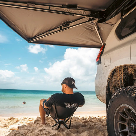 Outback Tourer Drivers Side 270 Plus Awning underside frame view above a person on a chair looking at the ocean.