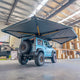 Outback Tourer Drivers Side 270 Plus X-Tend Awning rear underside view on a blue Jimny in a workshop.