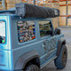 Outback Tourer Drivers Side 270 Plus X-Tend Awning closed in a black travel bag on a blue vehicle