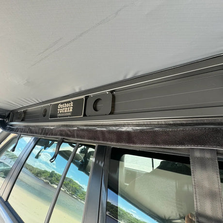 Outback Tourer Passenger Side 270 Awning back frame with Outback Tourer badge mounted on the passenger side of a vehicle.