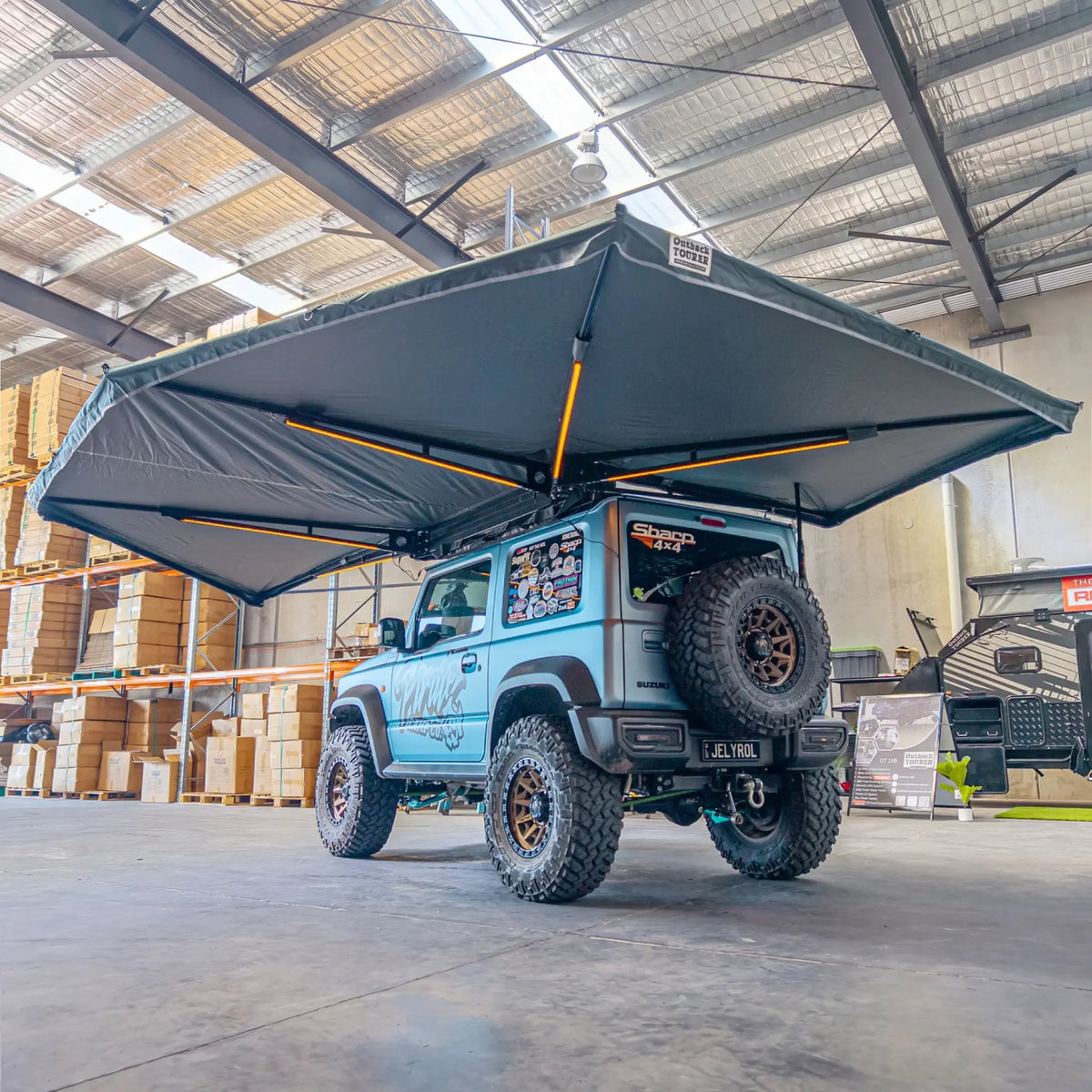 Outback Tourer Passenger Side 270 Plus X-Tend Awning rear-corner underside view on a blue Jimny.