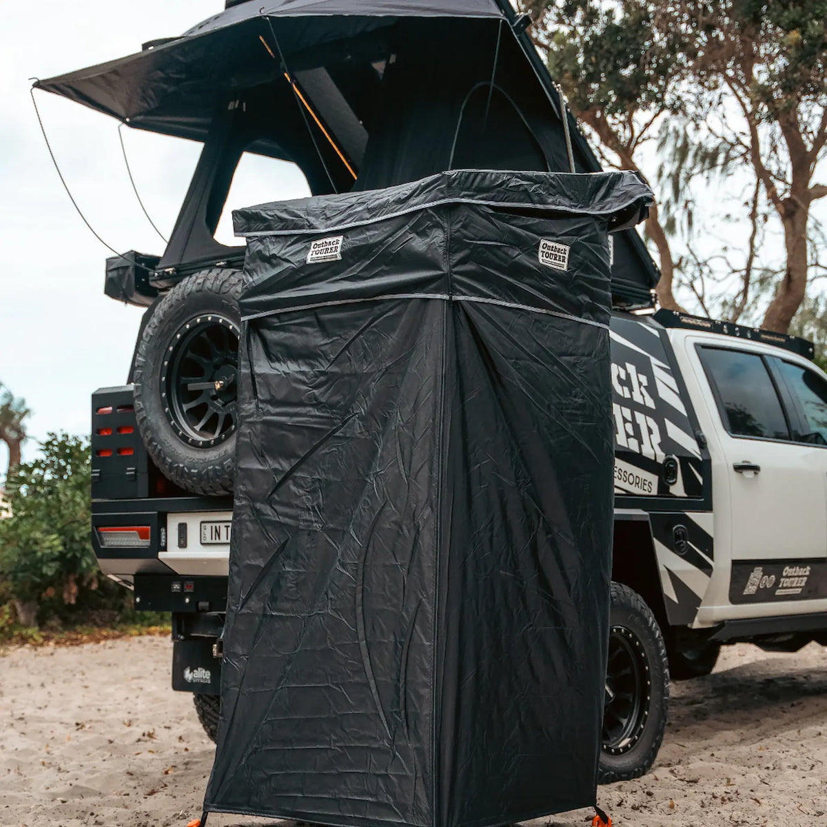 Outback Tourer Shower Awning close up view beside a vehicle on the beach.