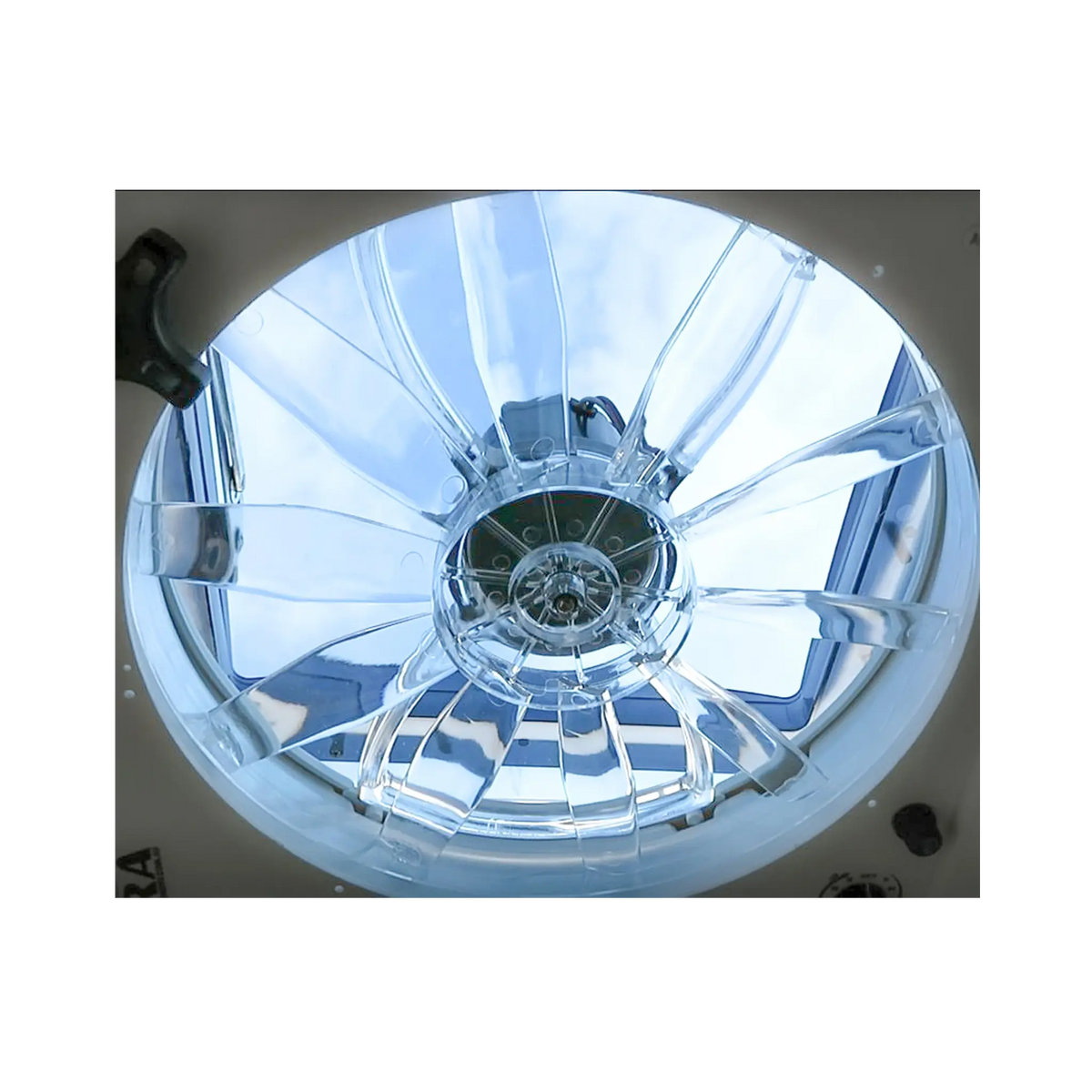 TRA 12V electric side vent roof hatch fan close up viewed from below through the clear blades.